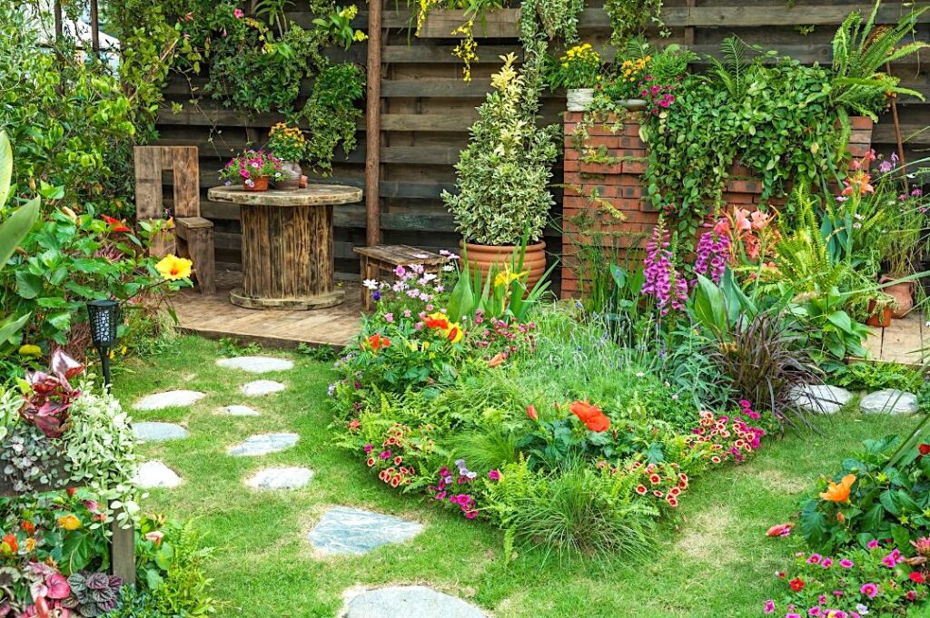 A charming and colorful cottage style flower garden with path and seating